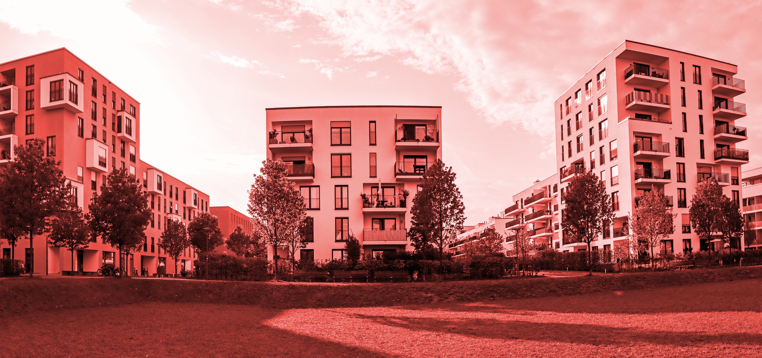 A red and white photo of a row of apartment buildings.