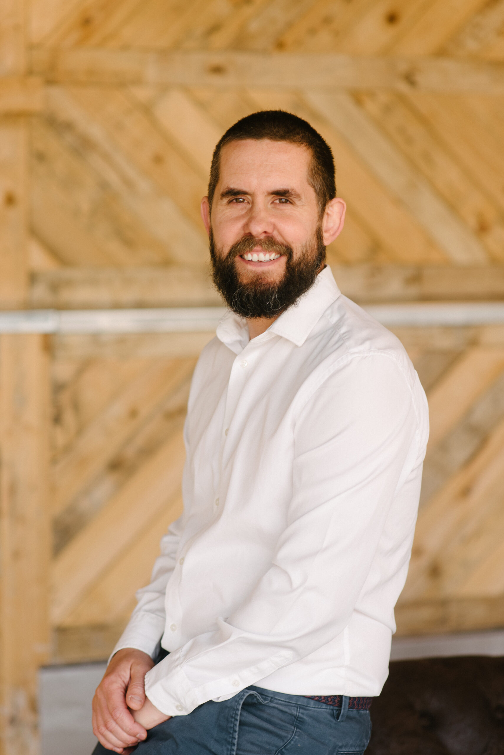 Paul Elliott, Managing Director of Propp, sitting in a reception area, wearing a white shirt and blue chino trousers.